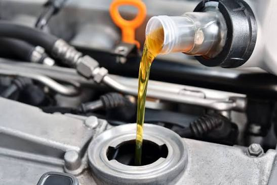 Fresh engine oil being poured during car oil service